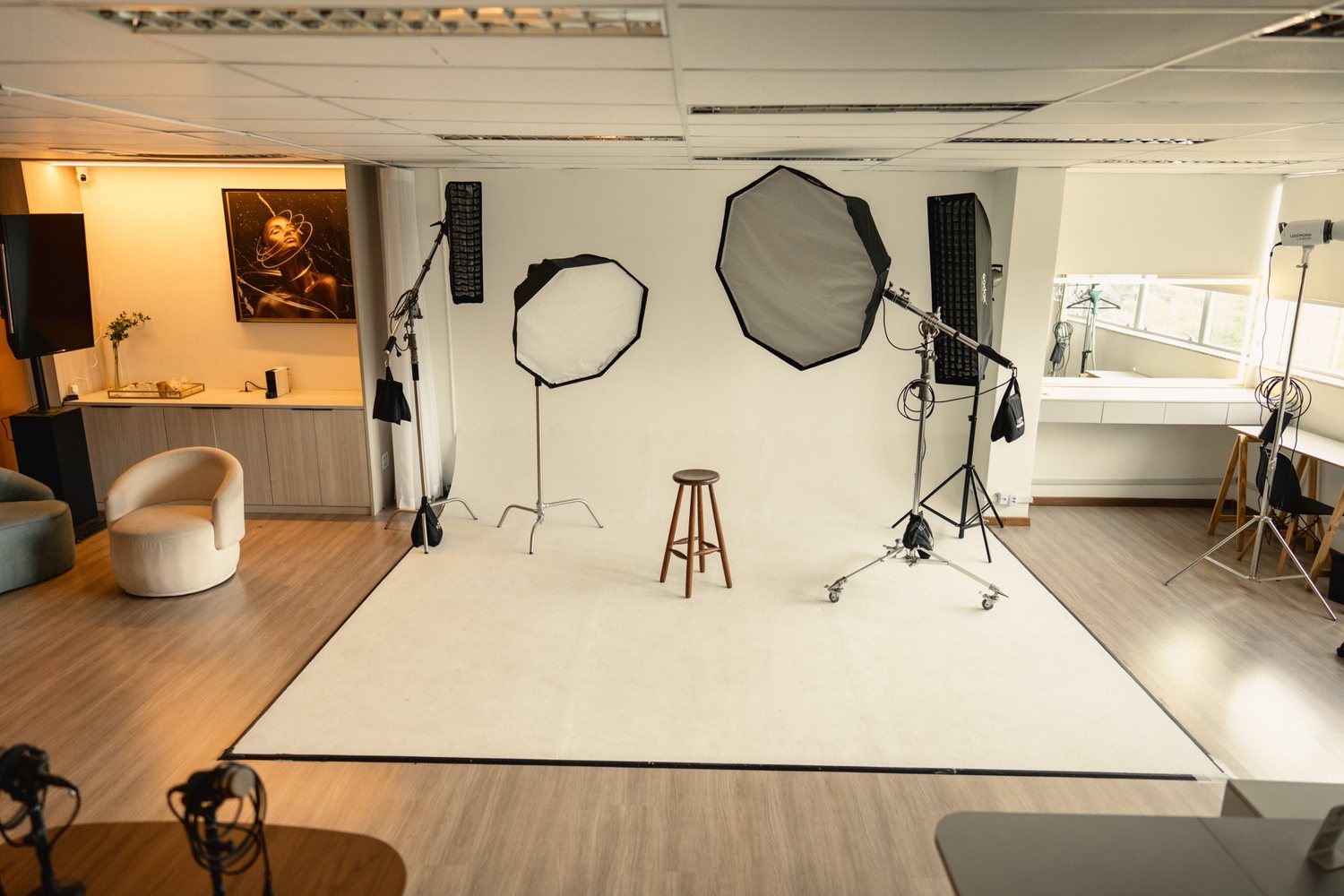 Sala principal do Estúdio 403: ciclorama branco, softboxes montados e janelas com luz natural.